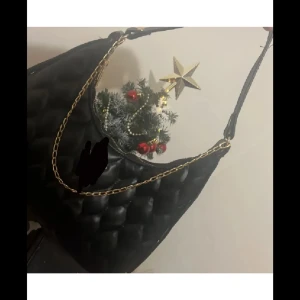 Svart quiltad axelväska med kedja - Snygg svart axelväska med quiltad design. Perfekt för att ge en elegant touch till din outfit. Väskan har en stilren look och är lätt att matcha med olika stilar.