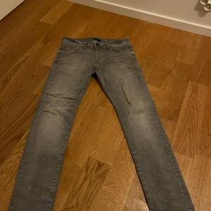 Grå jeans från Jack & Jones - Snygga grå jeans från Jack & Jones. De har en normal passform. Hör av dig vid funderingar!