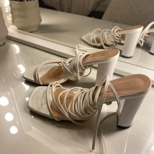 Klackskor - Vita höga klackskor st 38, använda en gång. Bandet knyter man upp mot vaden så skorna sitter bekvämt på🌸