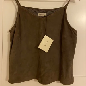 Brun top i mocka från Massimo Dutti - Säljer en brun top i mocka från Massimo Dutti. Helt oanvänd med lappen kvar. Nypris 899kr. Köp och använd nu!