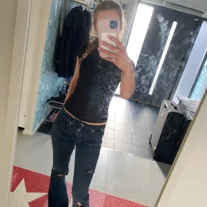 Mörkblå bootcut jeans med slitningar - Säljer ett par mörkblå jeans med bootcut passform och snygga slitningar på benen. 