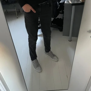 Grå slim fit jeans Slim Glenn - Säljer ett par mörkgrå slim fit jeans från Jack & Jones, modell Slim Glenn. Jeansen har klassisk femficksdesign, normal midja och raka ben. Perfekta för dig som gillar en smalare passform och stilren look.