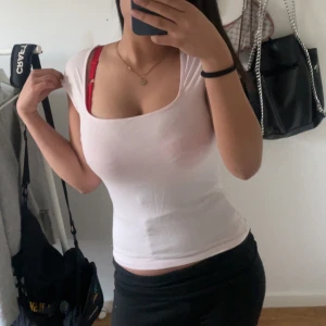 Rosa tight  topp - Säljer en rosa tight  topp med rundad halsringning. Toppen är ärmlös och sitter figurnära, perfekt för en enkel och stilren look.