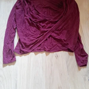 Vinröd omlottopp från Make Way - Säljer en vinröd omlottopp från Make Way i mjuk viskosblandning. Toppen har långa ärmar och omlottdesign framtill som ger en snygg och avslappnad look. Perfekt att styla med jeans eller kjol. Snygg till party eller fest. Jag ser inget att anmärka på. Använd 2 gånger 