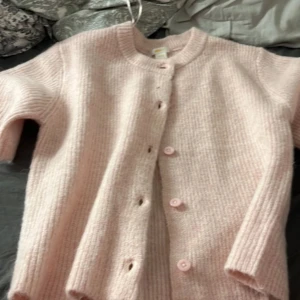 Ljusrosa stickad kofta från Gina Tricot - Säljer pågrund av att jag inte riktigt kunde se mig själv i den. Använd 1 gång och fick i december 2024 och typ inte använd. Den här skickas inte genom Plick utan med Swish och adress (inte Instabox)