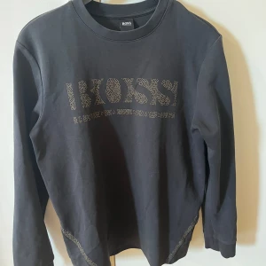 Svart långärmad tröja från BOSS - Säljer en snygg svart långärmad tröja från BOSS. Passar mest storlek M. Skriv privat för fler bilder☺️ 