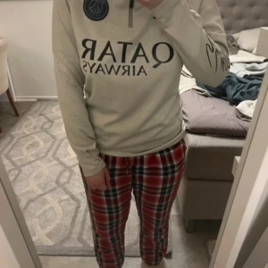 PSG långärmad fotbollströja med autograf - Säljer en ljusgrå långärmad PSG-tröja från Jordan med svart tryck och Qatar Airways sponsorlogga. Tröjan har PSG-emblem på bröstet och en stor autograf på ena ärmen. Perfekt för dig som älskar fotboll och vill sticka ut.