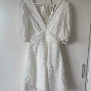 Vit klänning med puffärm - Söt vit klänning med puffärm och rosett i ryggen. Aldrig använd, nypris 499kr💕