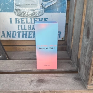 Louis Vuitton California Dream parfym - Louis Vuitton California Dream Eau de Parfum i en lyxig flaska med rosa och blå gradient. Flaskan är rundad med svart LV-logga på korken och kommer i exklusiv förpackning. Doften är fräsch och modern, perfekt för dig som gillar designerparfymer.