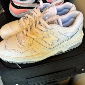 Vita New Balance 550 sneakers - Snygga New Balance 550 sneakers i helvitt skinn med klassisk siluett och tydliga loggor på sidan och hälen.