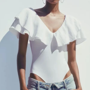 Vit volangtopp ifrån Zara - Superfin vit topp ifrån Zara  med djup v-ringning och stora volangärmar. Vid fler bilder skriv!🩷🩷endast använd en gång! 