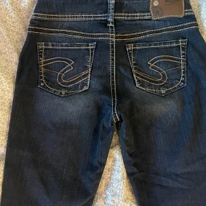 Mörkblå vintage-jeans - Så snygga vintage-jeans från Silver jeans. Broderade detaljer på fickorna. Fint skick. Low waist. Storlek: W26, L31