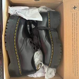 Dr. Martens Holly Plattformsskor  - Säljer dessa helt oanvända Dr. Martens plattformsskor i modellen Holly då de tyvärr inte passar mig och går ej att returnera längre. Denna modell säljs inte längre i Sverige så de är definitivt unika och perfekta skor till vardags och fest. De har aldrig använts mer än för att pröva och är fortfarande kvar i kartongen. De kommer med två par skosnören, ett par i vanlig sort och ett par i silke. Känn er fria att fråga vad ni vill, upphämtning i Stockholm innerstad och Ekerö/Bromma är möjligt! 💕