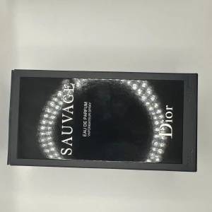 Dior Sauvage Eau de Parfum 100ml - Dior Sauvage Eau de Parfum i 100 ml flaska. Parfymen kommer i en elegant mörkblå glasflaska med silverfärgad text och svart lock. Doften är intensiv och maskulin, perfekt för dig som vill sticka ut med en modern och fräsch signaturdoft. priset ej hugget i sten vid snabbaffär!!