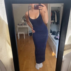 Mörkblå långklänning från SHEIN - Säljer en mörkblå långklänning från SHEIN i storlek S. Klänningen är tight, ärmlös och har smala axelband med en djup, rundad urringning. Materialet är stretchigt. Den påminner om skims klänningarna. Jag är 168vm lång och den slutat just vid mina anklar. Den har inga defekter.