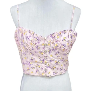 Ljuslila blommig croppad linnetopp - Helt oanvänd superfin ljuslila croppad linnetopp med små gula och lila blommor. Toppen har smala justerbara axelband, knappar framtill och lätt rynkade kupor för en söt och feminin look. Perfekt för varma dagar och somriga outfits.