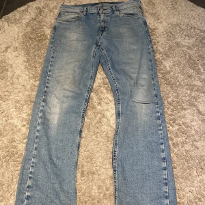 Ljusblå jeans från Replay - Säljer ett par ljusblå jeans från Replay med klassisk femficksdesign och snygga detaljer på bakfickan. Jeansen har normal passform och är tillverkade i mjukt bomullsjeansmaterial. Perfekta för dig som gillar en avslappnad och stilren look.