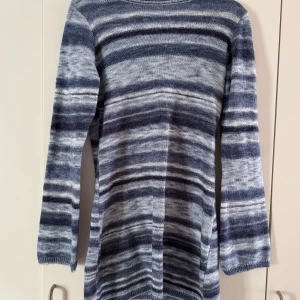 Stickad klänning med öppen rygg - Säljer en långärmad stickad klänning med blå och grå ränder från Nelly. Tröjan har en djup, rundad ringning i ryggen, samt en figurnära passform.💙🩵