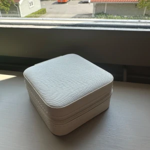 Vit smyckesask med spegel - Hej, denna fina smyckesbox säljs för att vi är ett gammalt uf-företag som har flera smyckesboxar över, vårat uf-företag hette Smyckesboxenuf som du kan hitta på både instagram och tiktok, dessa smyckesboxar hann vi inte få sålda och därför säljer vi dom här, har 4st mörkgröna dom är oanvända och fina, en perfekt storlek till när man ska ut och resa!🩷
