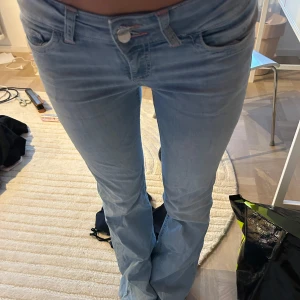 Ljusblå bootcut jeans med rosa brodyr  - Säljer ett par ljusblå bootcut jeans från nelly med rosa brodyr, ett litet hål vid ena ficka där sömnen har gått up💕