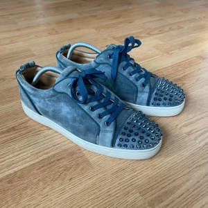 Christian Louboutin - Väldigt eftertraktade Christian Louboutin i ljusblå färg. Skorna är i bra skick med täcken på användning. Finns healdrag, spikarna är lite skadade på vänstra skon. Storlek 43 1/2 passar även 44. Tveka inte att kontakta vid minsta lilla fundering så svarar vi så fort som möjligt. 