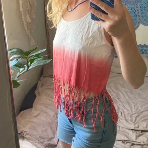 Vit och rosa fransig linnetopp - Säljer en superfin vit och rosa linnetopp med dip dye-effekt. Toppen är croppad med långa fransar och små pärlor längst ner. 