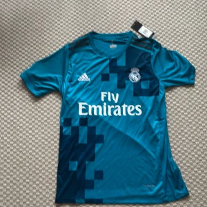 Real Madrid Ronaldo 7 Adidas tröja - Säljer en Snygg blå Real Madrid fotbollströja med Adidas märke på och Ronaldo 7 på ryggen från 2017/2018 Champions legue finalen I storlek S för 599kr