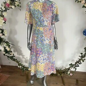 Supersöt Pastellblommig midsommar/sommarklänning - Superfin långklänning med blommigt mönster i pastellfärger som lila, gul, blå och rosa. Klänningen har korta ärmar, rund hals och ett flowy fall. Perfekt för dig som älskar färg och vill sticka ut med en söt och somrig vibe.