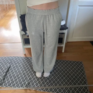 Grå mjukisbyxor  - Säljer ett par grå mjukisbyxor med bred resår i midjan och raka, lösa ben. Byxorna är i mjukt bomullsmaterial och har en avslappnad passform. 