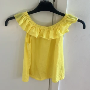 Gul volangtopp från H&M - Säljer denna superstat gula topp från hm i storlek 140 men passar som Xs då den är stretchig💓