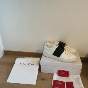 Valentino Garavani Open sneakers vit/svart - Snygga Valentino Garavani Open sneakers i storlek 43 i nyskick, använda ca 2 gånger. Nypris ca 7000kr, inköpta på valentinos hemsida. Perfekta för dig som gillar stilrena och lyxiga sneakers med en modern twist. Pris ej hugget i sten så kom gärna med bud 😁🙌🏻
