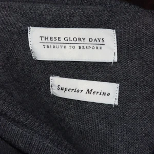 Mörkgrå merino polotröja These Glory Days - Snygg mörkgrå polotröja från These Glory Days i mjuk och lyxig merinoull. Tröjan har lång ärm, ribbade muddar och klassisk polokrage. Perfekt för lager-på-lager och stilrena outfits. Superior Merino-materialet gör den extra skön och värmande.