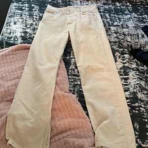Beige straight jeans Junkyard Nevermind - Snygga beige jeans från Junkyard Nevermind i rak modell. Byxorna har klassisk femficksdesign och är tillverkade i ett mjukt bomullstyg. Perfekta för dig som gillar en clean och stilren look.