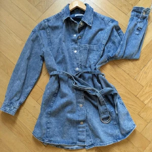 Bershka oversize jeansjacka  - Oversize jeansjacka med bälte. Slitningarna ska vara så. I bra skick! Passar XS-M, beroende på hur du vill att den ska sitta. Jag är storlek S och den sitter väldigt löst på mig. 100% bomull. 