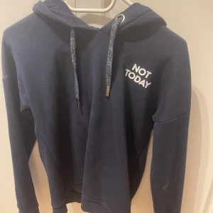 Mörkblå hoodie med tryck  - Säljer en mörkblå hoodie med huva och glitter snören☺️ bröstet står det 'NOT TODAY' och på ryggen 'MAYBE TOMORROW'.Perfekt för chill och nice vibe stil 💕💕