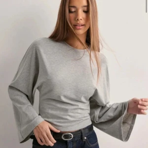 Grå tröja med vida ärmar - Säljer en stilren grå tröja med vida ärmar. Perfekt för en avslappnad look. Tröjan har en normal passform och är tillverkad i ett mjukt material.