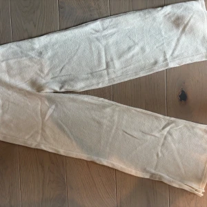Beige mjukisbyxor från Kappahl - Beiga mjukisbyxor från Kappahl i storlek 146. Byxorna är tillverkade i ett mjukt och bekvämt material, perfekta för chill dagar hemma eller när du vill ha det extra skönt. Klassisk rak passform och elastisk midja för bästa komfort.
