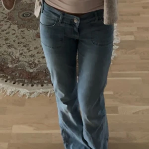 Blå bootcut jeans med fickdetaljer - Snygga blå bootcut jeans med låg midja. Knappt använda därav att dom inte passar, köpt för 700kr. 
