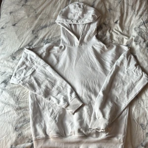 Vit hoodie från Studio Total XS - Säljer en clean vit hoodie från Studio Total i storlek XS. Tröjan har huva, långa ärmar och en klassisk känguruficka framtill. Mjuk bomullskvalitet som är skön att ha på sig och passar perfekt till chill dagar. Enkel och stilren design utan mönster eller detaljer. Obs två små små fläcker se bild 2