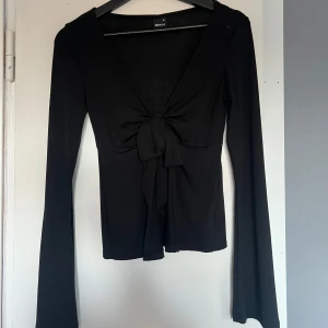 Tie Front Long Sleeve Top - Fin tröja från Gina tricot med knytning fram. Tröjan har vida ärmar längre ned och är i storlek XS. Använd 2-3 gånger💞
