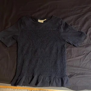 Svart blus med volang från Gina Tricot - Supersöt svart blus från Gina Tricot med korta ärmar. Har inte använt så mycket eftersom att den blev för liten snabbt, den är i väldigt bra skick. 😻