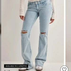 Bootcut ljusblå jeans med slitningar - Snygga ljusblå bootcut jeans med slitna hål över knäna och broderade detaljer på bakfickorna. Sparsamt använda!!🙌🙌💓💓nypris 699