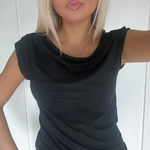 Svart ärmlös topp - Snygg svart topp med ärmlös design och draperad halsringning. Enkel och stilren modell som passar perfekt till jeans eller kjol💞💞