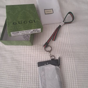 Gucci korthållare svart (snake) - TAR HELST EMOT BYTEN!!!!!!  Gucci korthållare i svart skinn med ikoniskt GG-mönster och en cool röd och vit orm på framsidan. Plånboken har dragkedja, flera kortfack och en grön-röd handledsrem. Perfekt accessoar för dig som vill sticka ut med lyxig streetstyle.