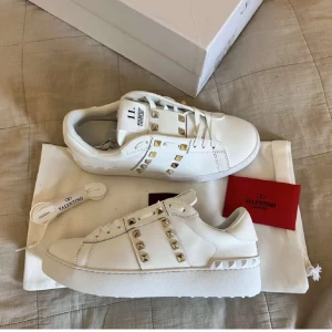 Valentino Rockstud vita sneakers - Säljer vidare dessa snygga ÄKTA vita Valentino Rockstud sneakers i storlek 38 men passar även 37-37,5 Dam. Säljer dom på grund av fel storlek. Helt nya och oanvända!! Man får med alla tillbehör som skolåda, extra skosnören, dustbag.