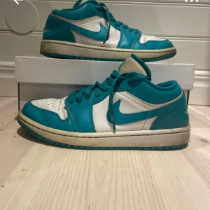Nike Air Jordan 1 Low Turkos/Vit - Nike Air Jordan 1 Low i en fräsch turkos och vit färgkombination. Skorna har klassisk snörning, rund tå och perforerad tåbox. Tillverkade i skinn med ikoniska Air Jordan-loggan broderad på hälen. Perfekta för dig som vill sticka ut med en unik färg på dina sneakers.