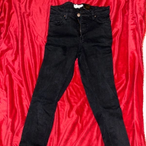 Svarta  jeans - Svarta jeans med klassisk femficksdesign och dragkedja. Snygg passform som sitter tight hela vägen ner. Perfekta till sneakers eller boots och funkar året runt. Jeansen har en mörk tvätt och är gjorda i stretchigt denim för extra komfort.