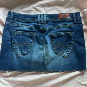 Lågmidjad jeansskjol LTB - Jättesnygg blå lågmidjad jeansskjol från LTB med slitningar. Jag har klippt kjolen själv som nu är ca 29-30 cm lång (kan vara lite ojämnt‼️). Kjolen är i bra skick. Midjemåttet är 39 cm💕 Köpde denna på plick och klippte lite kortare än vad förra ägaren hade gjort. Kjolen har inte kommit till användning sedan dess! 💕 