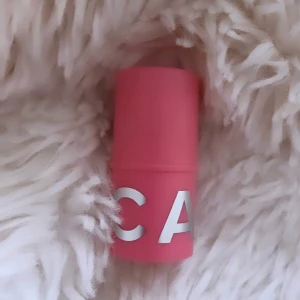 Caia Blush Stick Cupcake Glaze - Blush stick från Caia Cosmetics i färgen Cupcake Glaze. Kommer i en söt rosa hylsa med vita bokstäver. Enkel att applicera direkt på kinderna för en fräsch och naturlig look. Perfekt att ha i väskan för touch-ups under dagen.