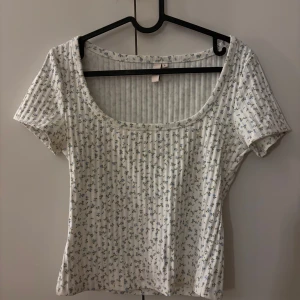 Vit blommig ribbad topp/t-shirt - Jätte söt vit top med blått blommigt mönster, köpte den från Nelly och har bara använt en gång så den är som ny ❤️ 
